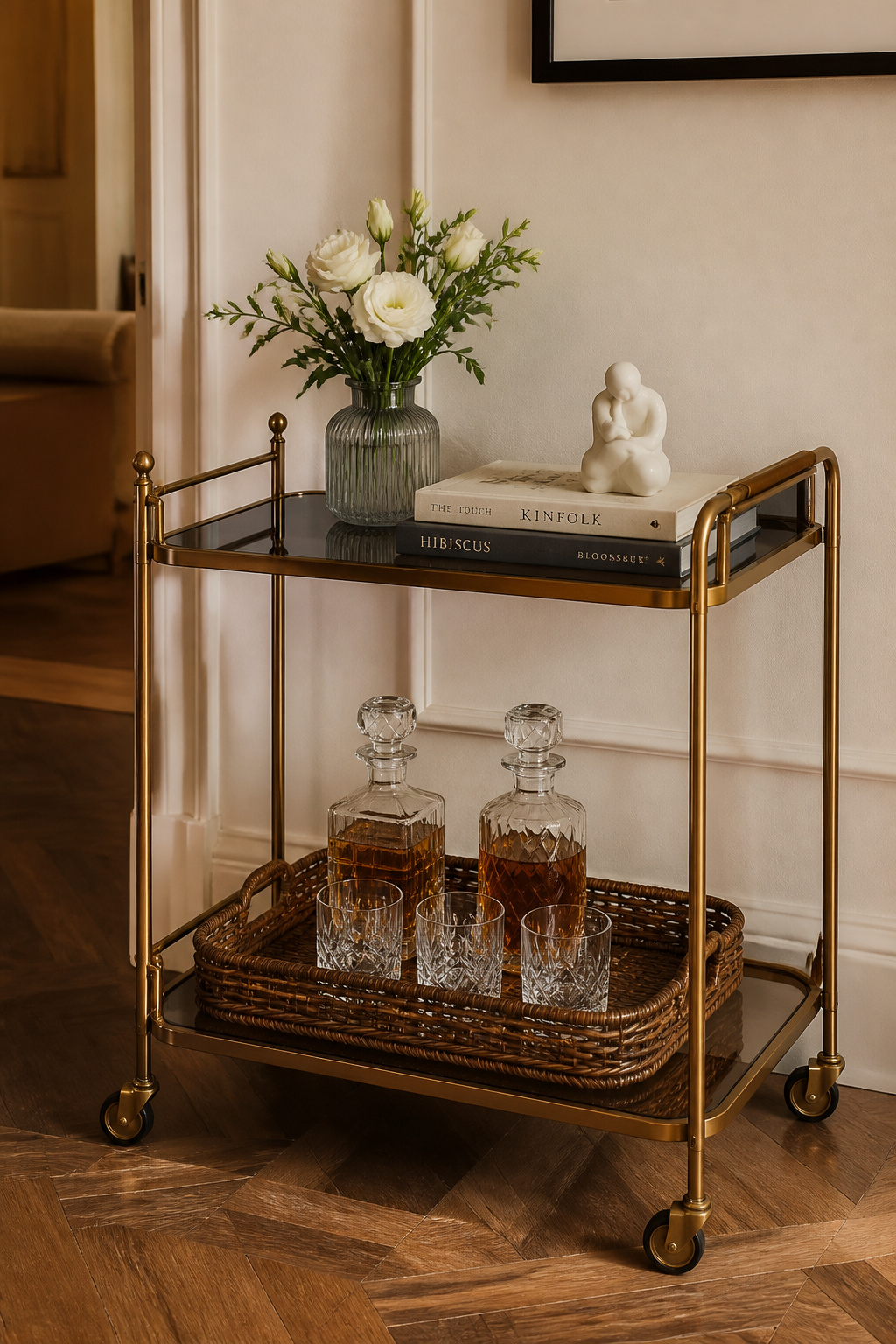 The bar trolley works as both a functional piece and a personality declaration — glassware, a small vase, and two books tell the room's story in three objects.