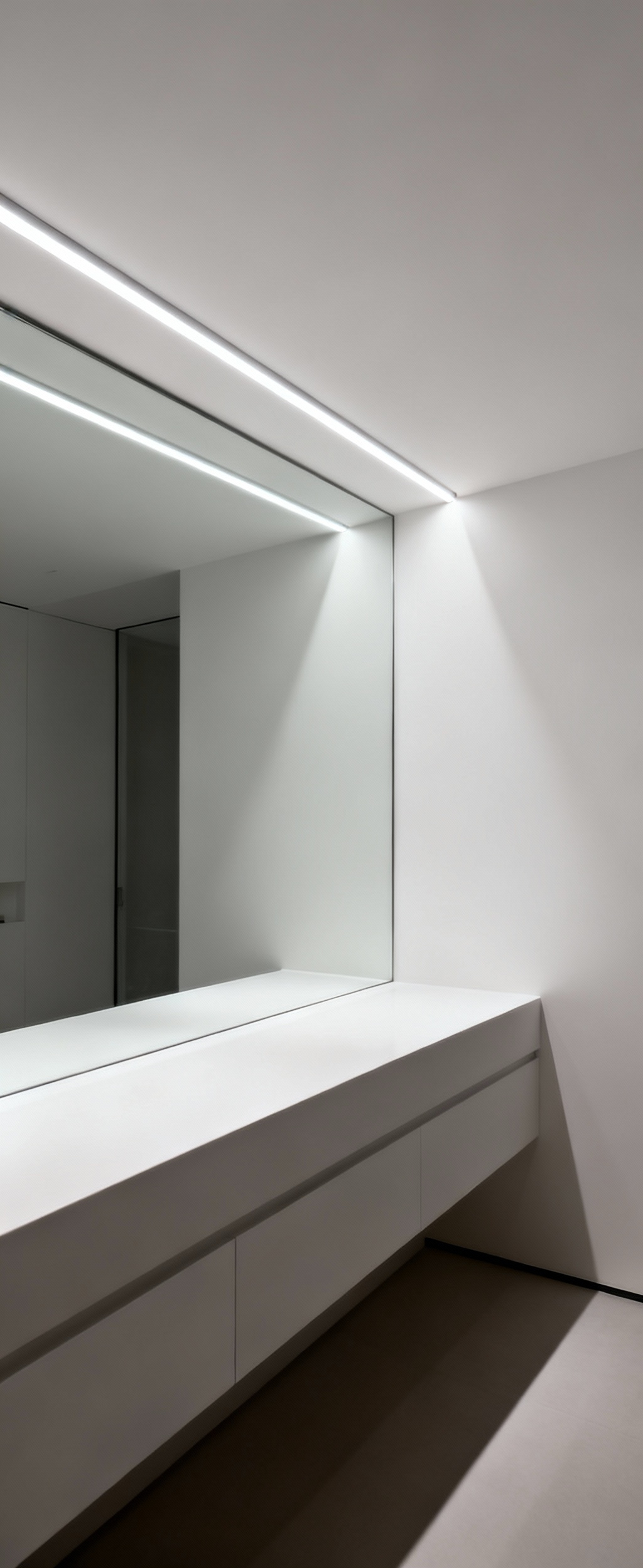 Bathroom vanity with linear LED indirect uplighting reflecting off a white ceiling, creating uniform, shadowless illumination and a calm atmosphere.