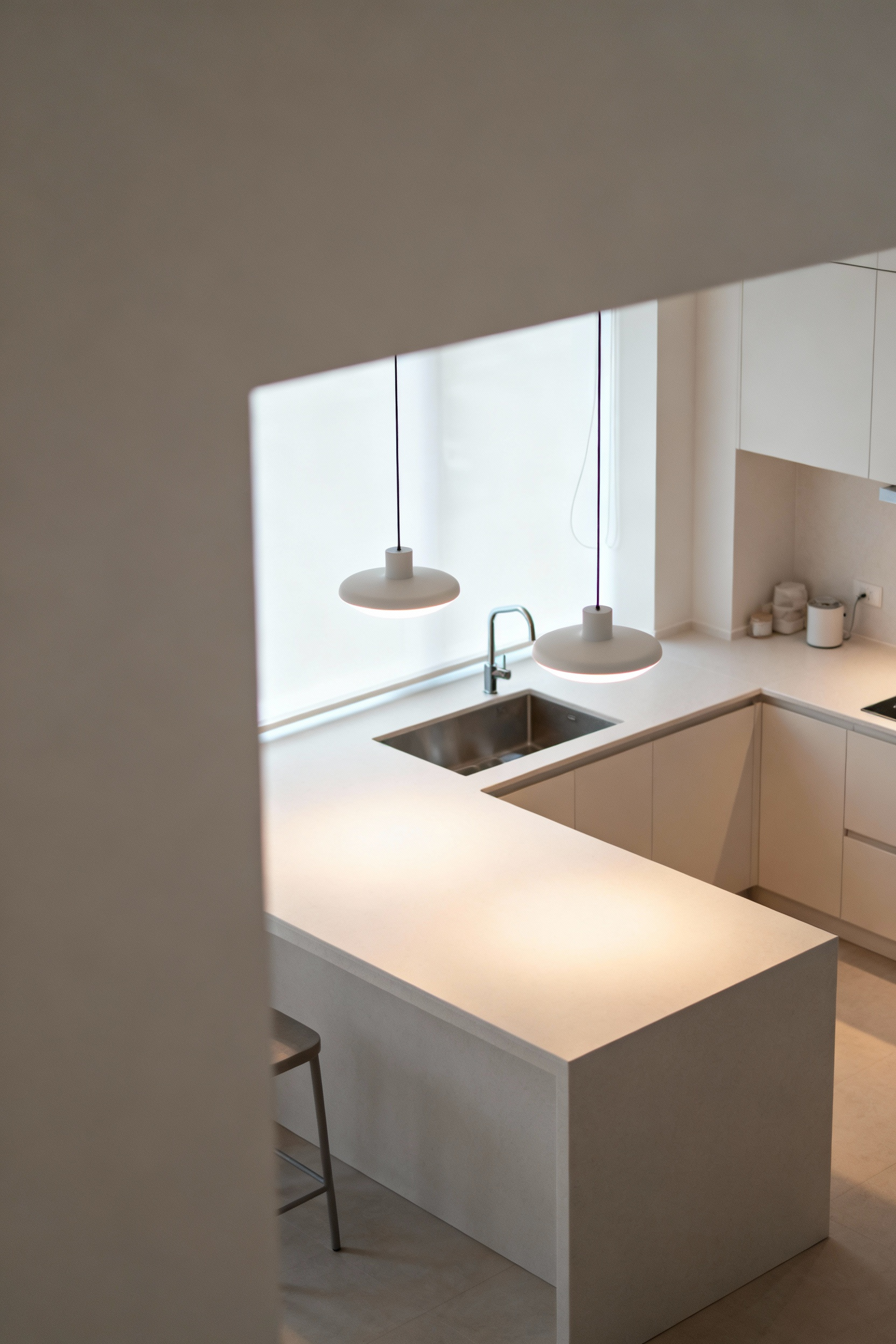 A clean, modern kitchen island with minimalist pendant lights designed for low-EMF emissions, reflecting a focus on healthy and serene home environments.