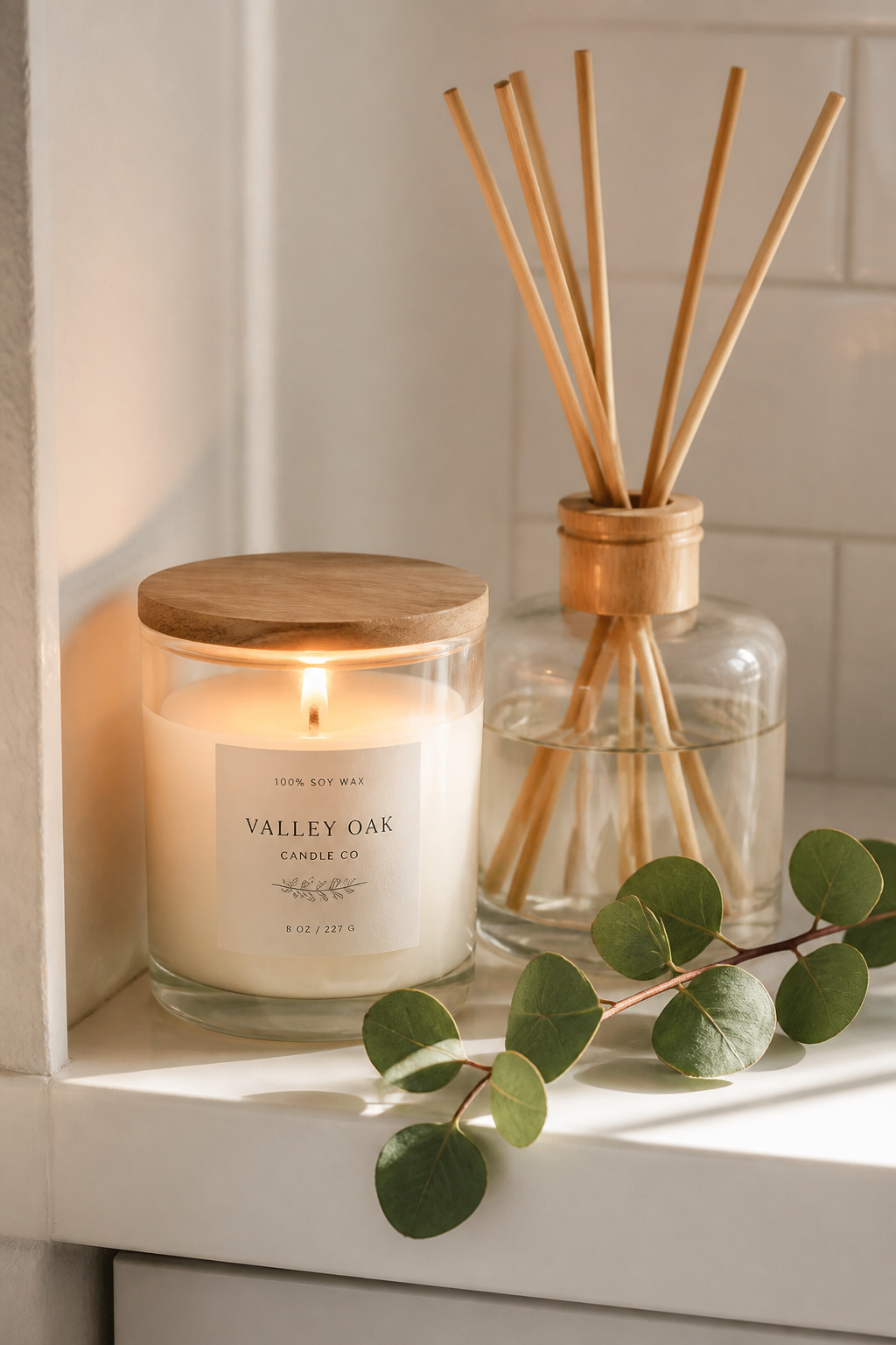 A soy wax candle, reed diffuser, and eucalyptus sprig create spa-level scent without synthetic fragrance compounds.