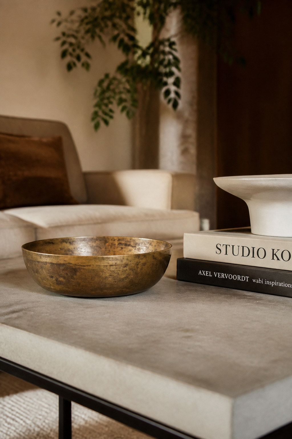A vintage brass bowl with genuine patina carries more character than any new piece — its history, surface variation, and implied age give a coffee table arrangement the one quality that money can't replicate.