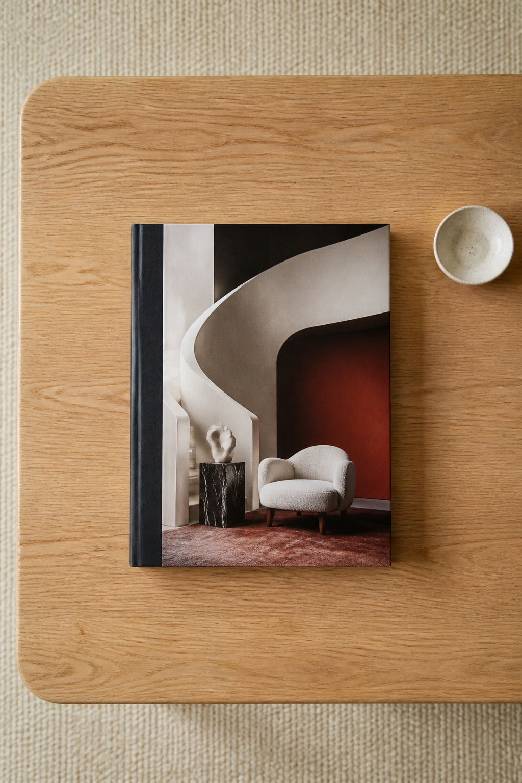 A large-format art book displayed face-up is a confident editorial choice — its cover artwork becomes part of the room's visual story, and the book itself becomes a conversation piece.