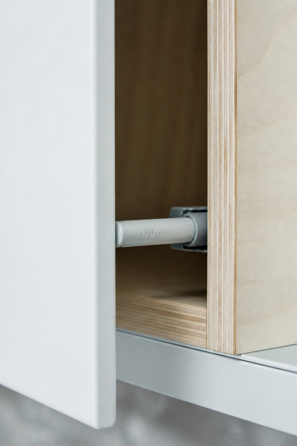 The Blum TIP-ON spring catch — rated for 80,000 cycles — is the mechanism behind the clean face of a handleless contemporary kitchen, visible here as the door releases at its 10mm push point.