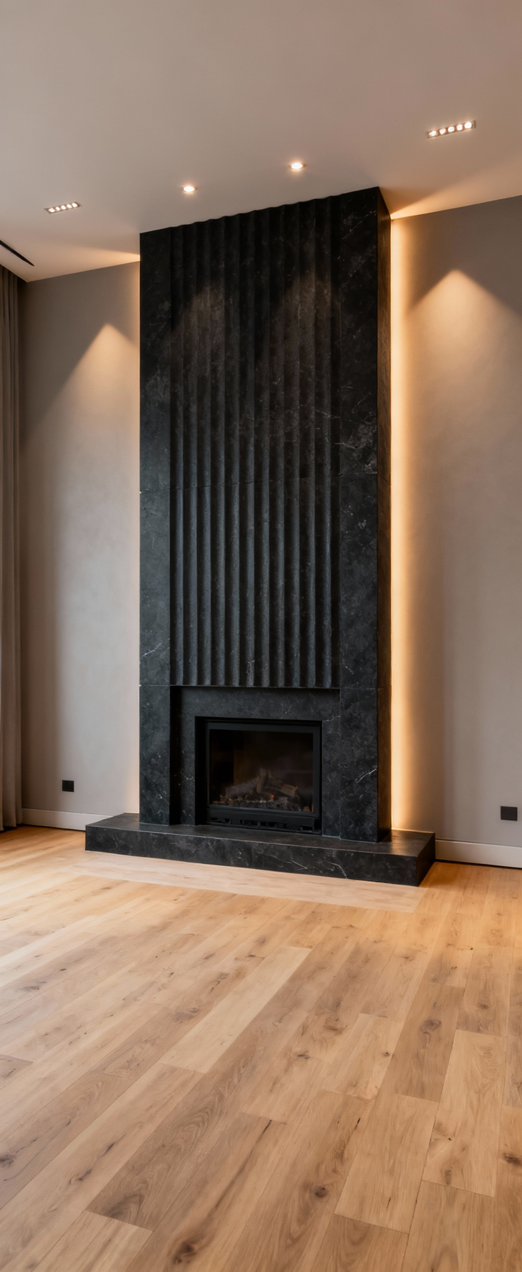 A contemporary living room featuring a dramatic charcoal fluted stone fireplace as a central focal point, expertly lit to create visual depth and presence, set against subtle greige walls.