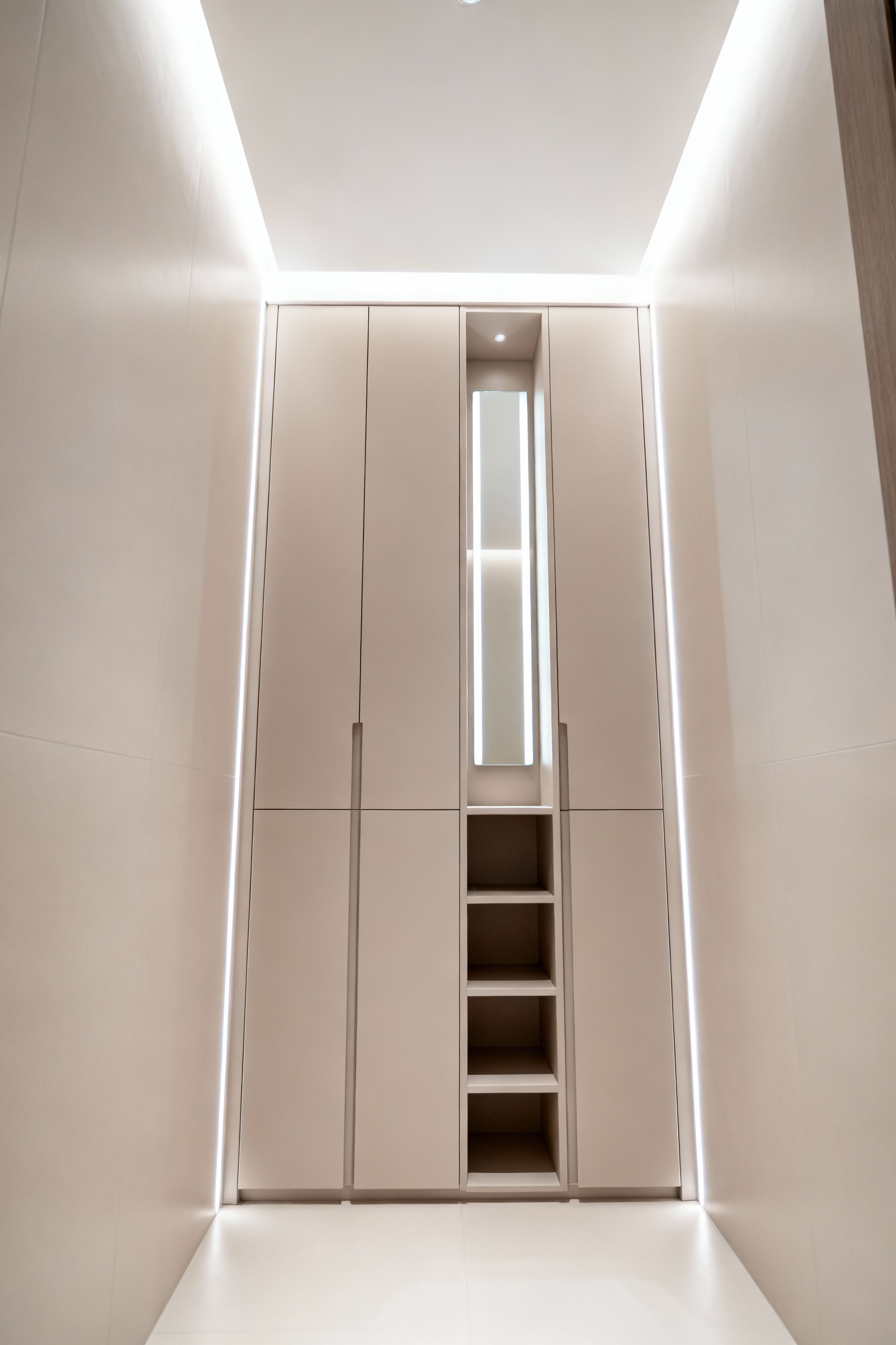 Modern small bathroom with integrated floor-to-ceiling white storage cabinet, featuring subtle vertical LED lighting and sleek design to maximize space and enhance verticality.