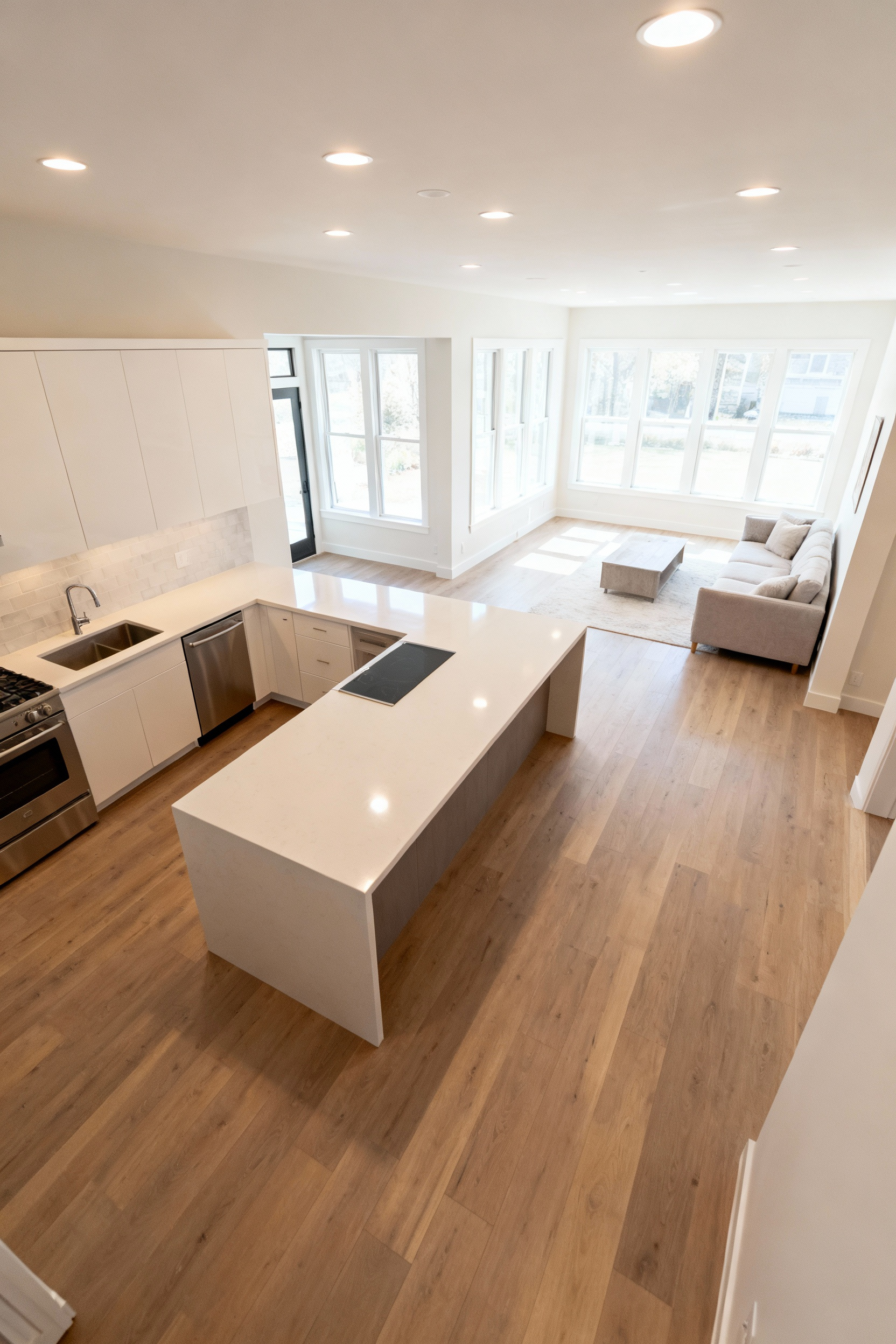 Modern open concept kitchen integrated with living room, showcasing seamless design and abundant natural light after strategic wall removal.