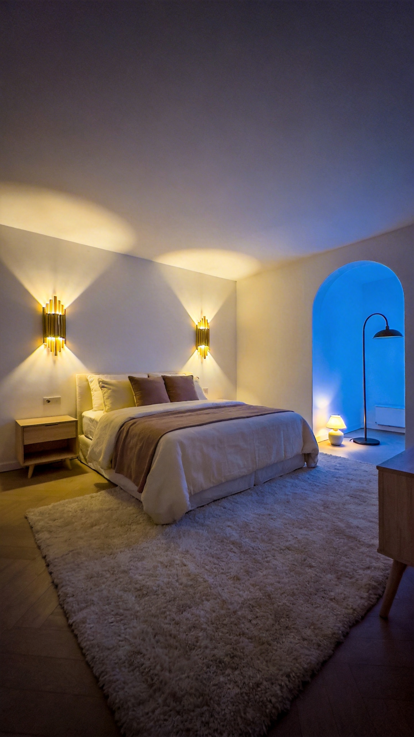 A cozy bedroom interior featuring perimeter lighting with wall sconces and a floor lamp illuminating the corners to create a safe and relaxing atmosphere.