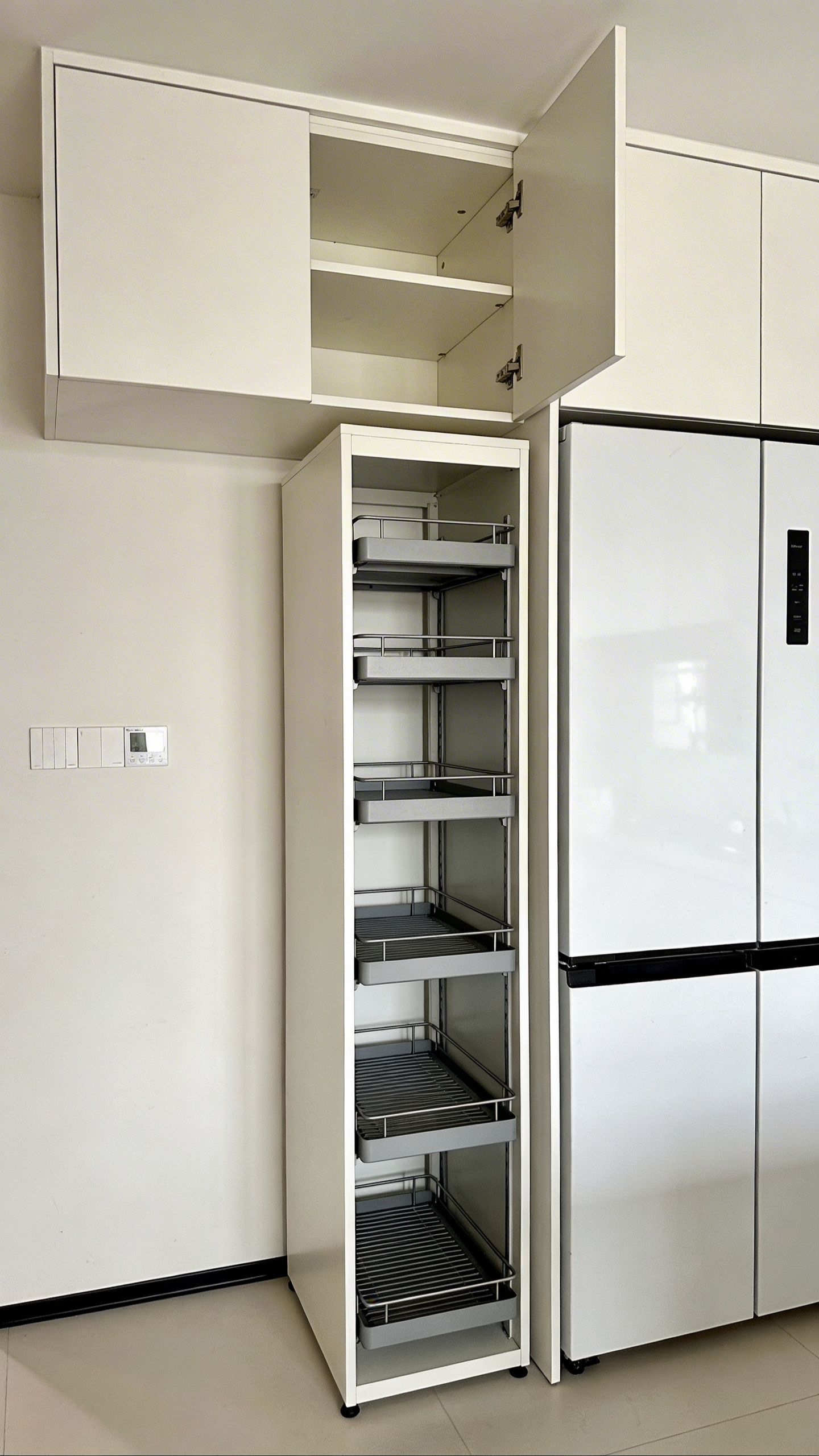 Vertical storage — shelf risers inside cabinets, a freestanding pantry tower against a blank wall — is the most overlooked dimension in small kitchen organization.