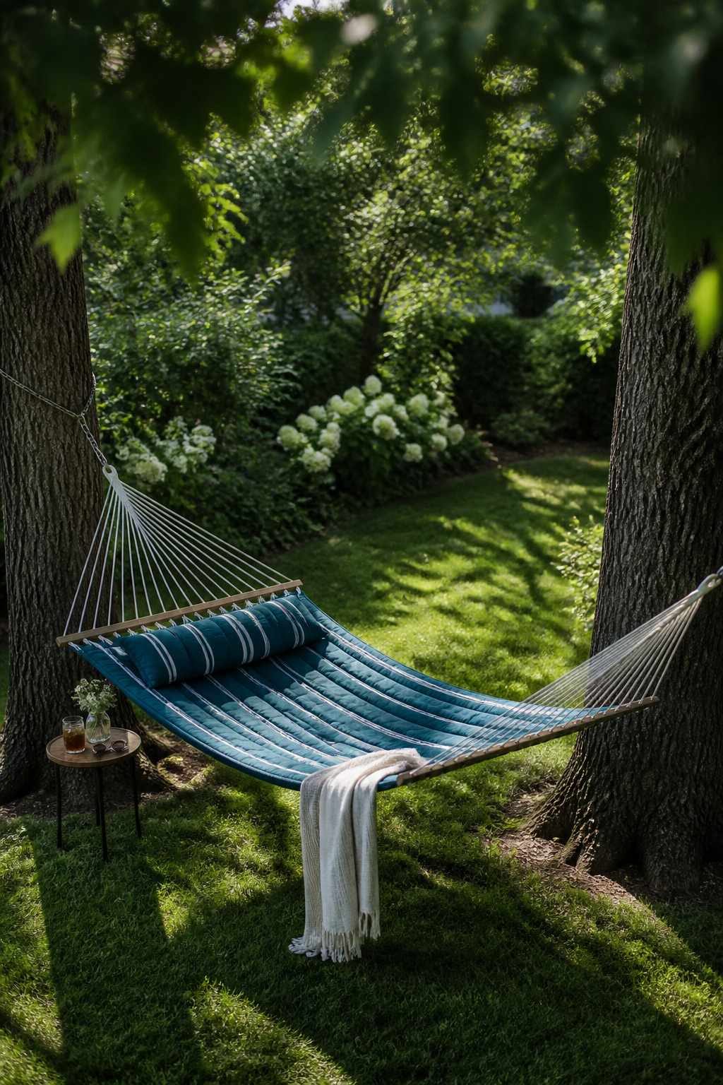 A quilted Sunbrella hammock hung between mature oaks creates the backyard's most magnetic spot — the piece that guests gravitate toward and linger in longest.