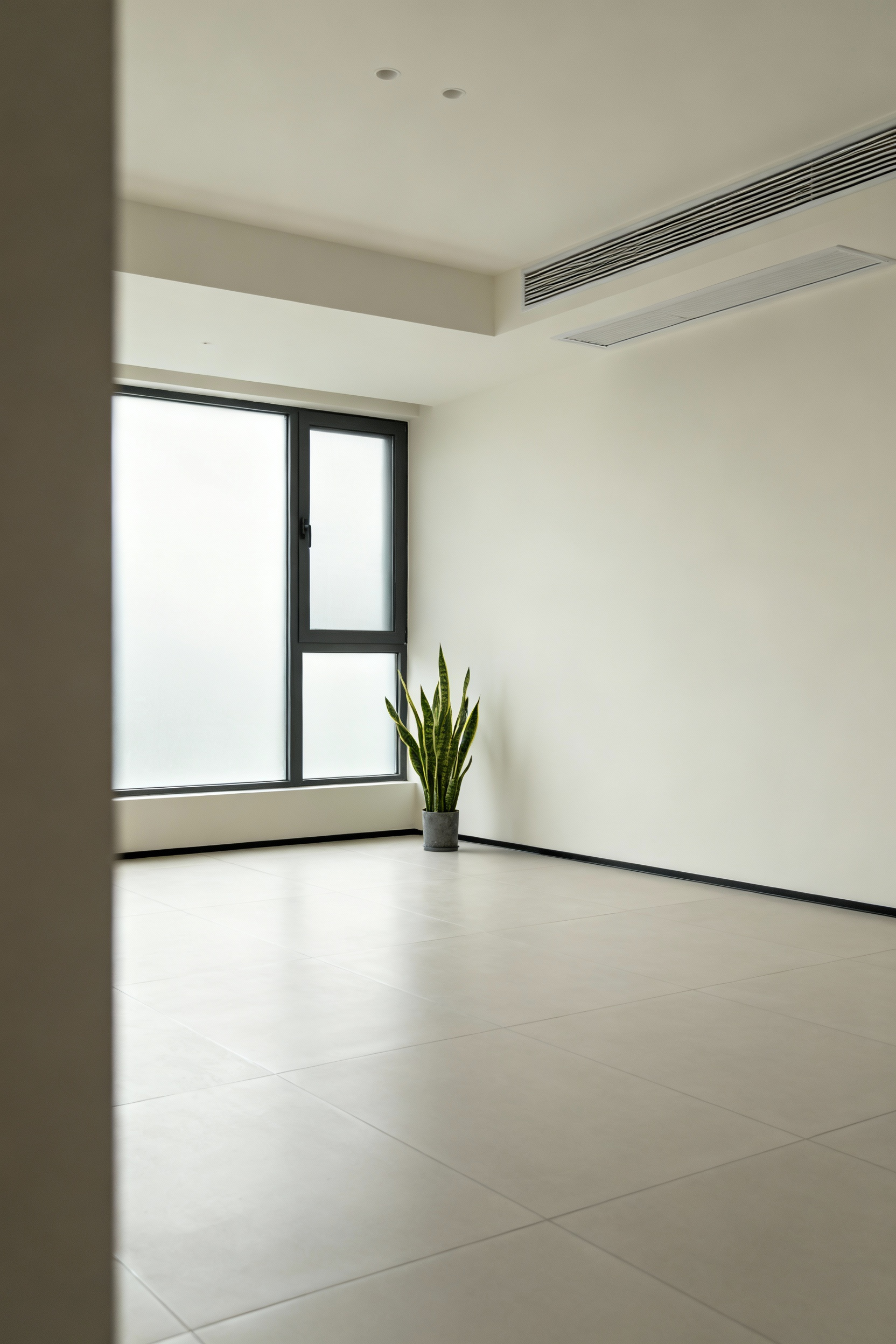 A pristine, minimalist bathroom with sleek low-VOC porcelain tile flooring, illuminated by natural light, featuring a discrete ventilation system and a potted snake plant, symbolizing fresh indoor air.