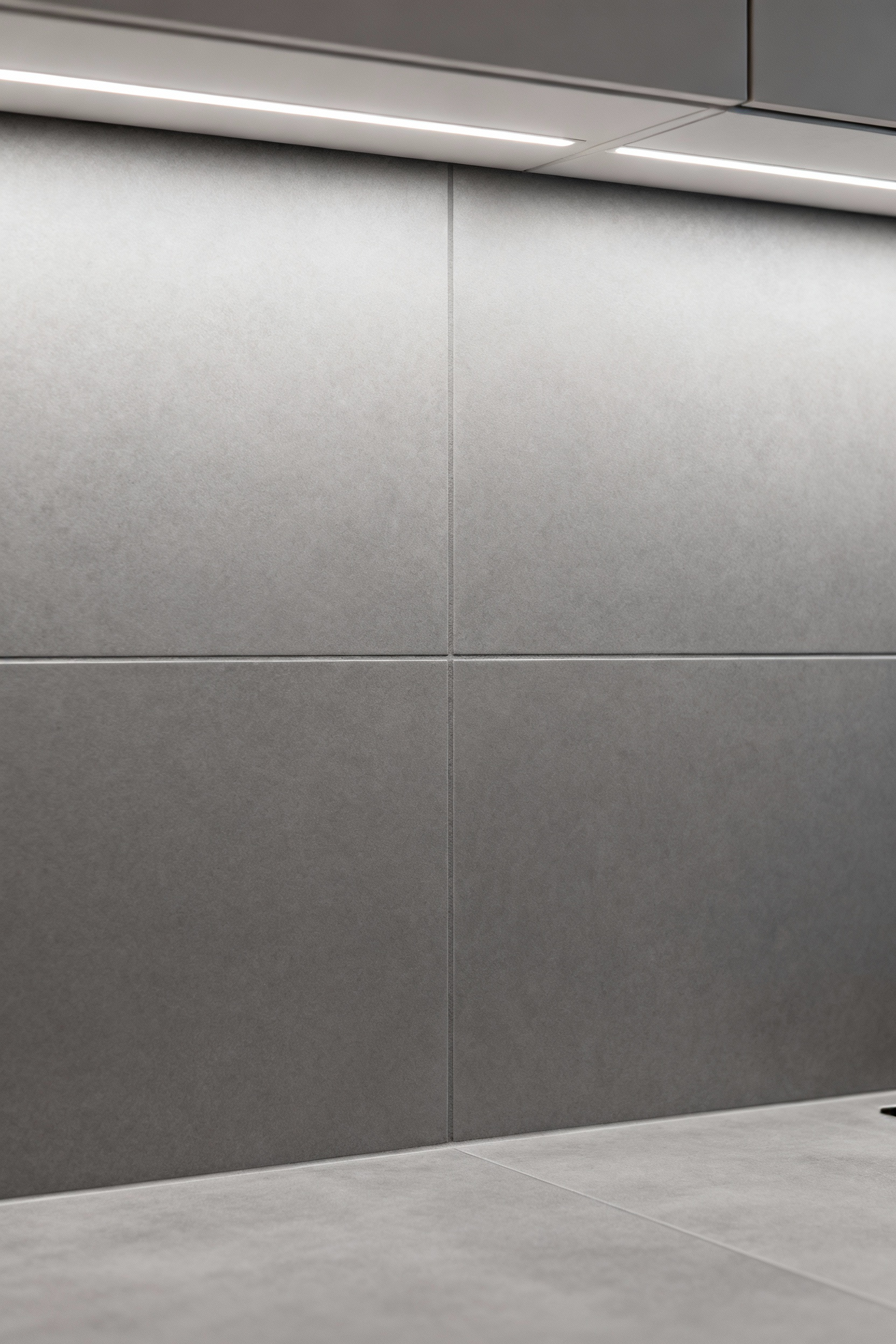 A modern kitchen backsplash featuring large gray porcelain tiles with nearly invisible, color-matched grout, illustrating seamless integration and a sophisticated finish.