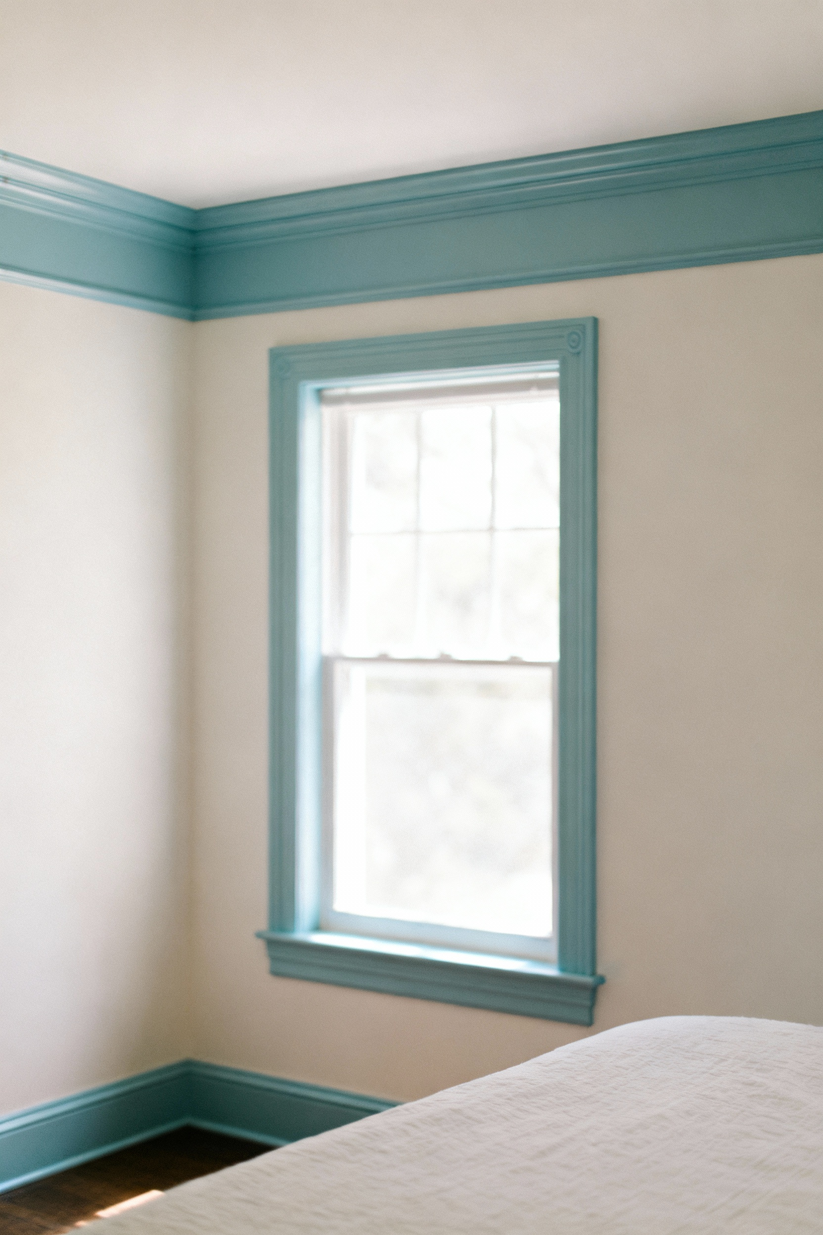 Bedroom featuring bespoke pale cerulean blue trim on crown molding, window casings, and baseboards against off-white walls, creating a serene and cohesive interior design.