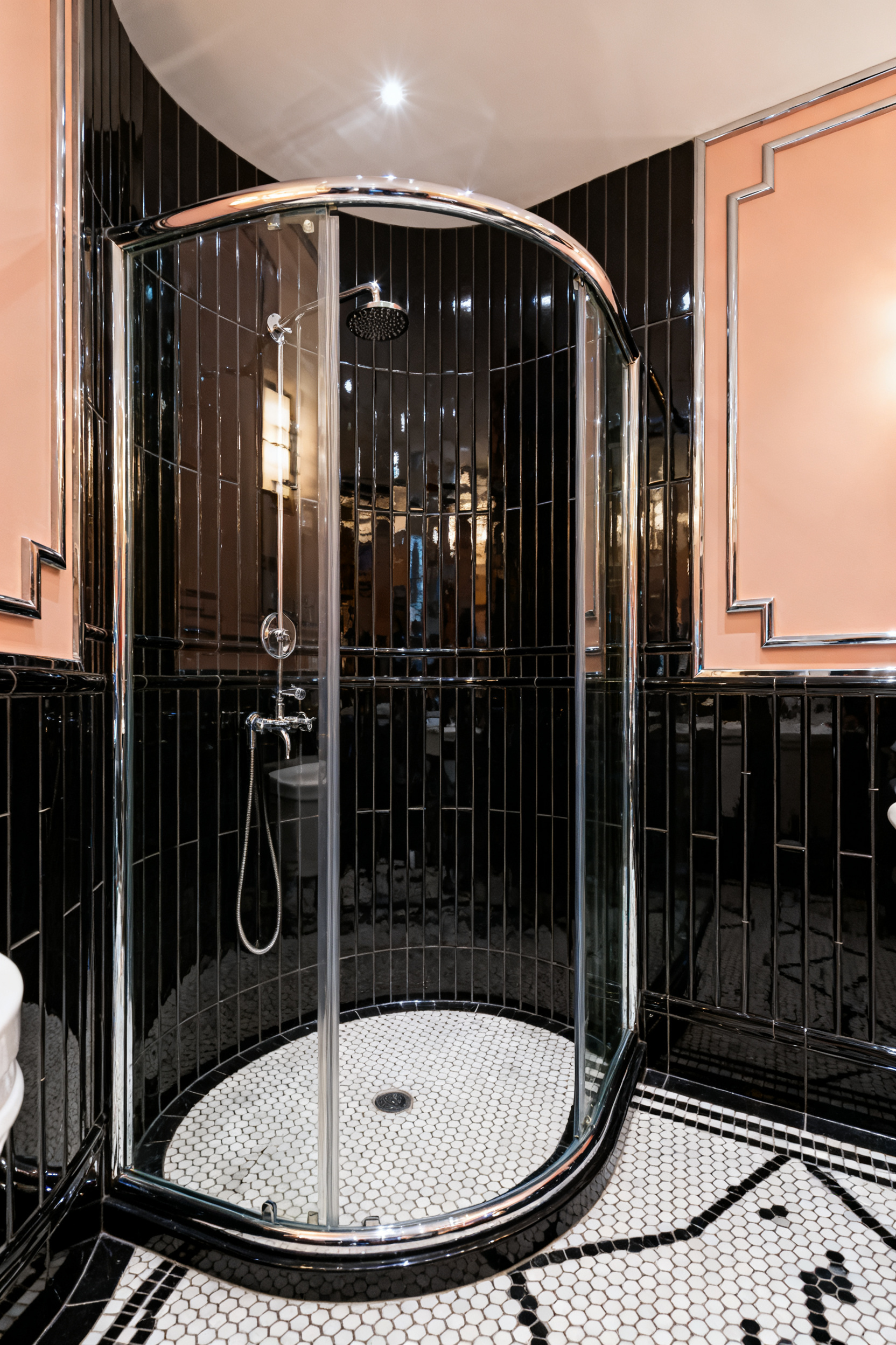 A luxurious Art Deco bathroom featuring a fan-shaped quadrant shower enclosure with highly curved glass and polished chrome fixtures, emphasizing the Streamline Moderne aesthetic.