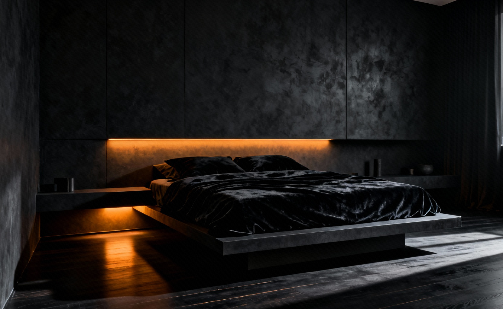 A modern, luxurious bedroom with matte black walls and layered dark bedding, illuminated by a single strip of warm recessed amber light to illustrate an environment designed for maximum darkness and deep sleep.