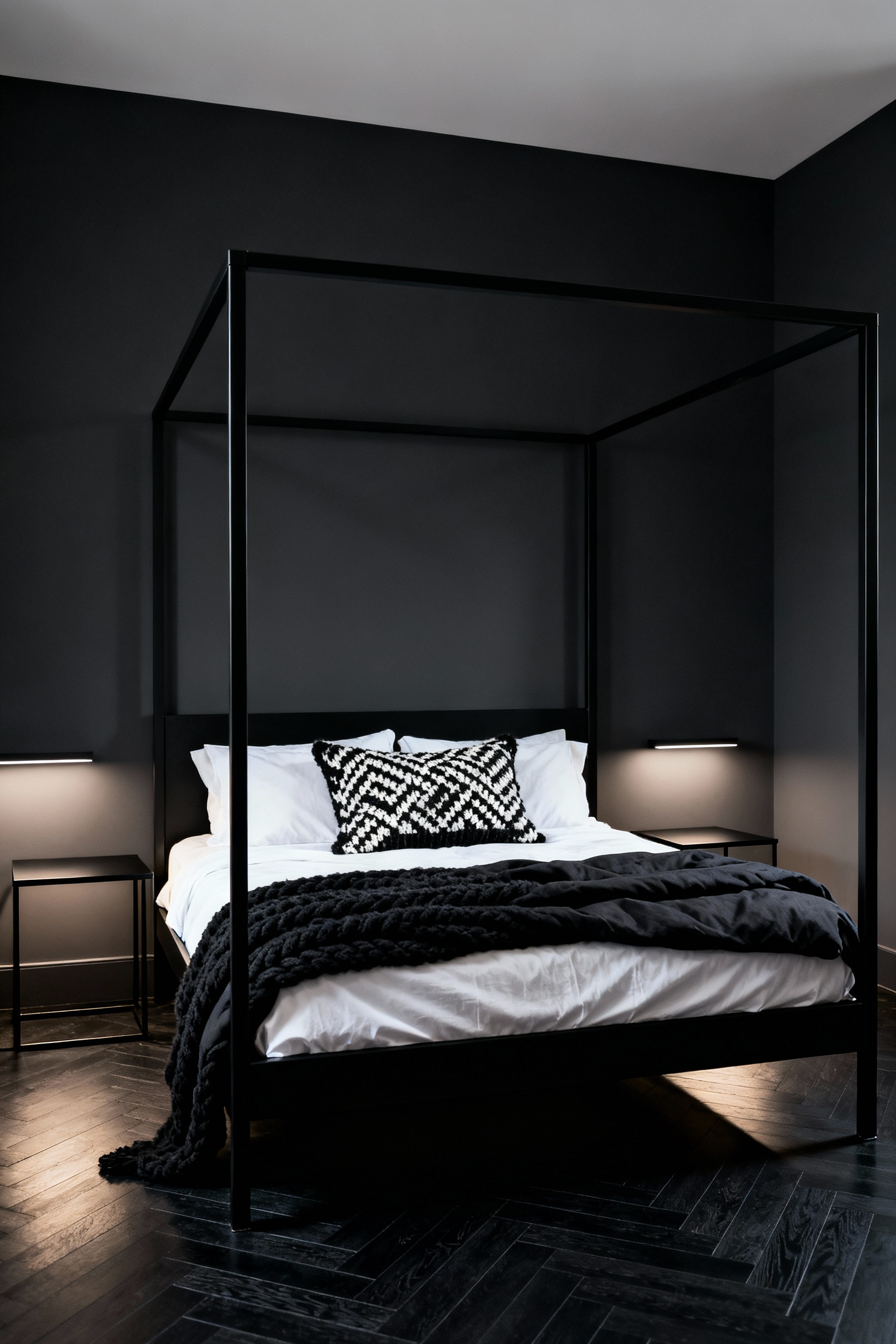 A dramatic matte black iron four-poster bed with geometric lines anchoring a dark charcoal bedroom, accented with layered high-contrast black and white luxury bedding.