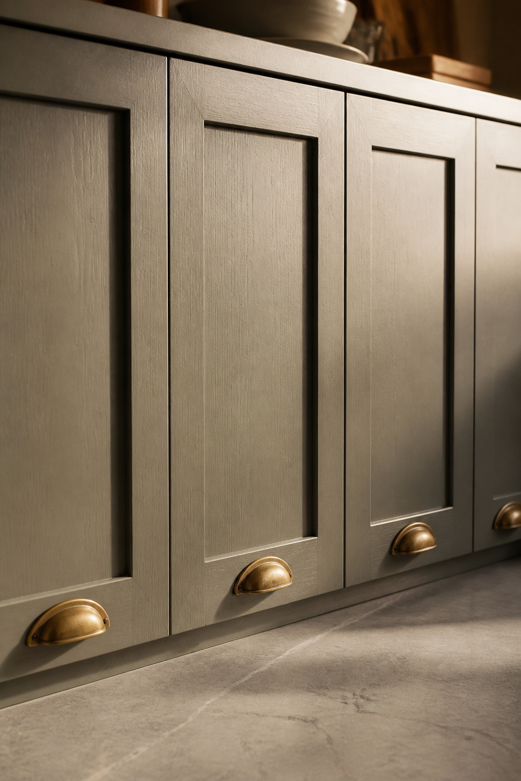 Shaker doors in earthy heritage tones — paint that acknowledges light and shadow — give the rustic kitchen its architectural backbone.