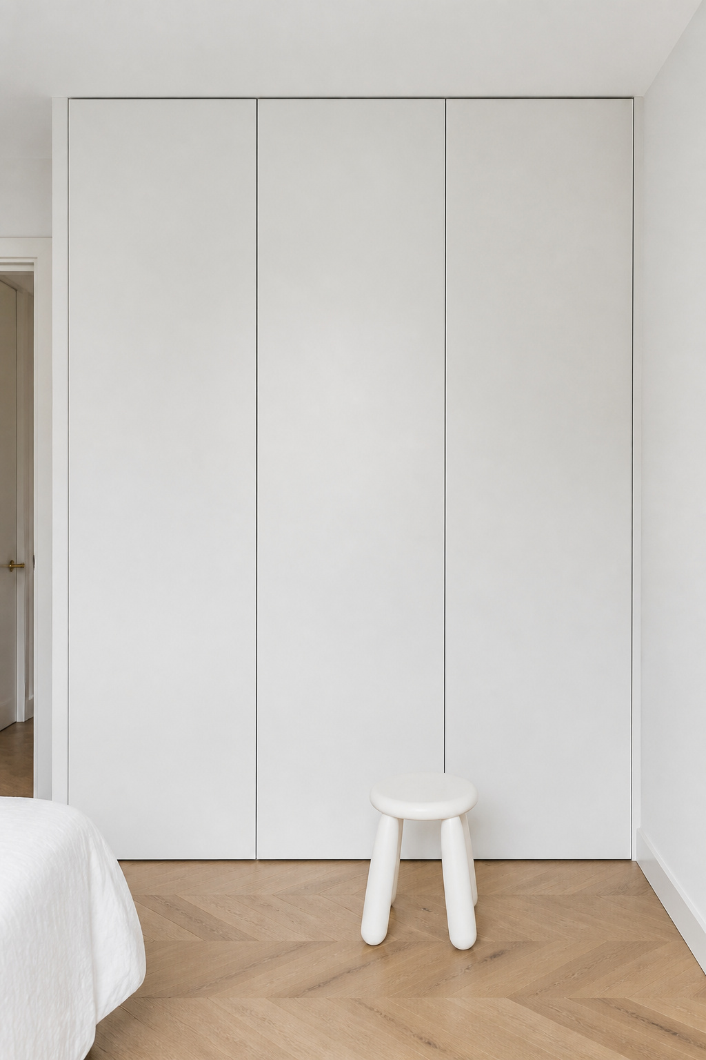 White built-in storage recedes against white walls, keeping white bedroom decor uncluttered and visually calm.