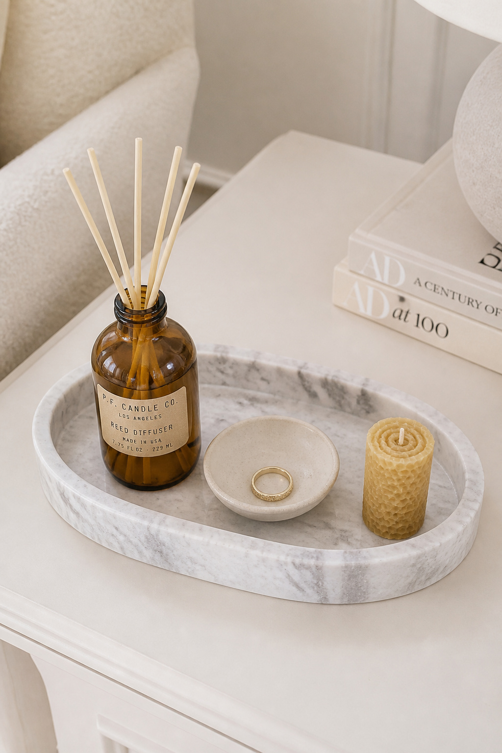 A marble tray corrals three functional objects into a deliberate vignette — the tray does the work of making the arrangement look intentional.