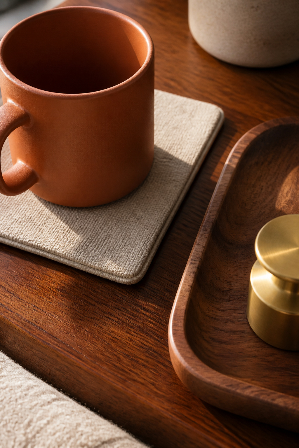Linen, ceramic, and wood in a single end table arrangement — three textures that each catch light differently, making the composition richer than colour alone.