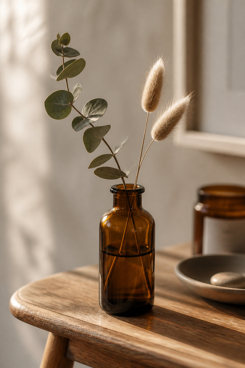A single eucalyptus stem in a thrifted amber bottle — the simplest botanical end table decor move that works every time.