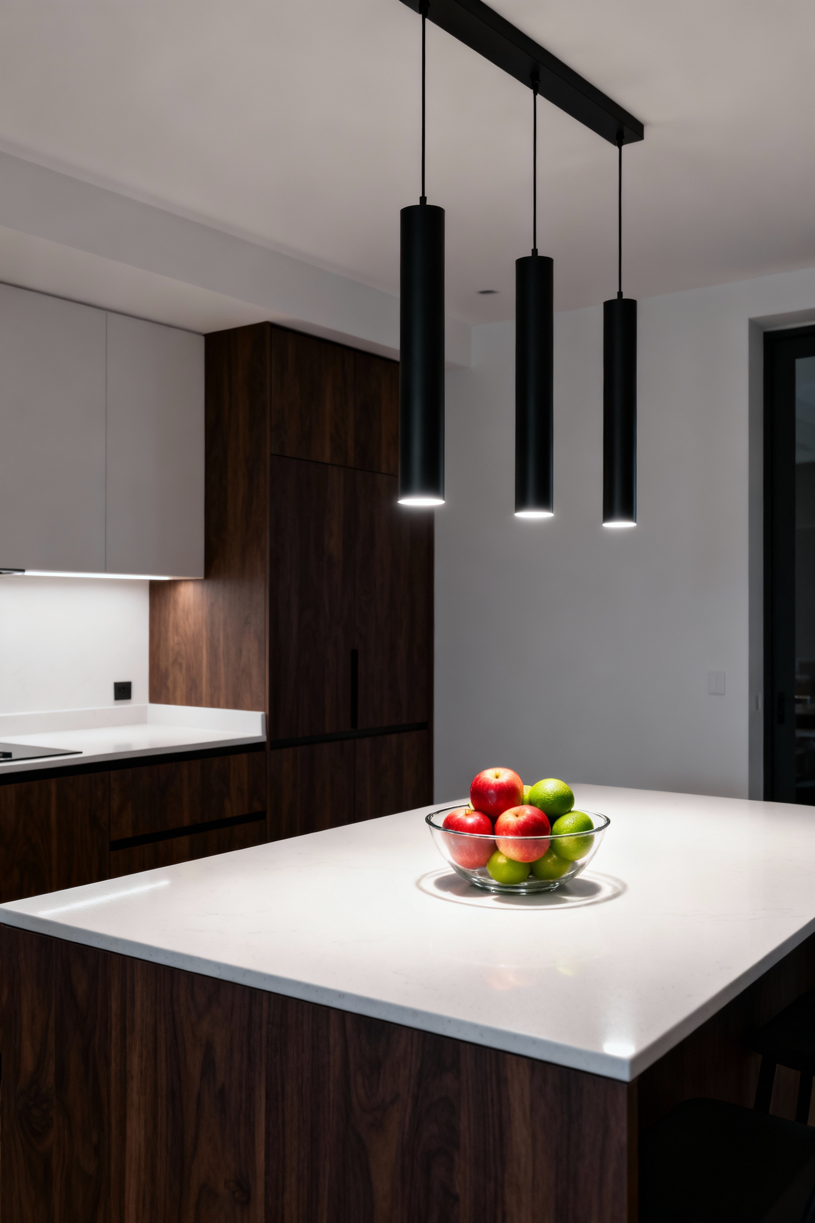 Three modern black pendant lights illuminate a white marble kitchen island with soft 3000K lighting, showcasing the perfect neutral white balance for a residential kitchen.