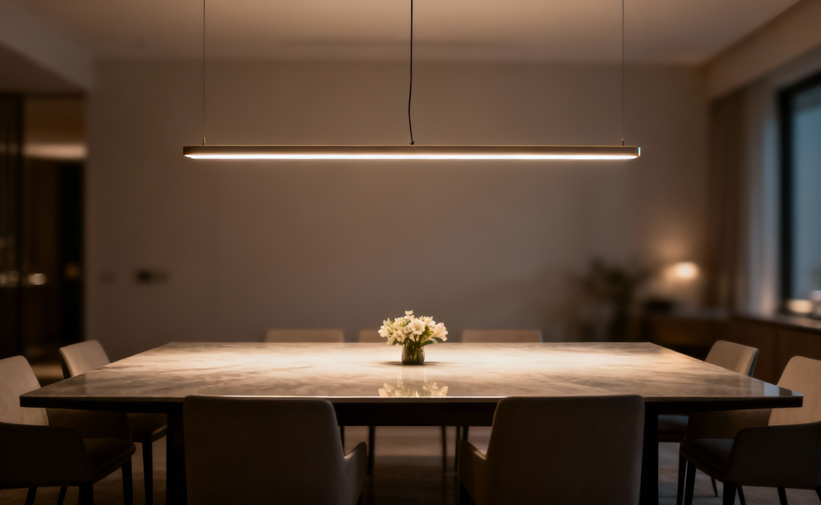 Elegant linear pendant light perfectly illuminating a rectangular dining table in a modern dining room