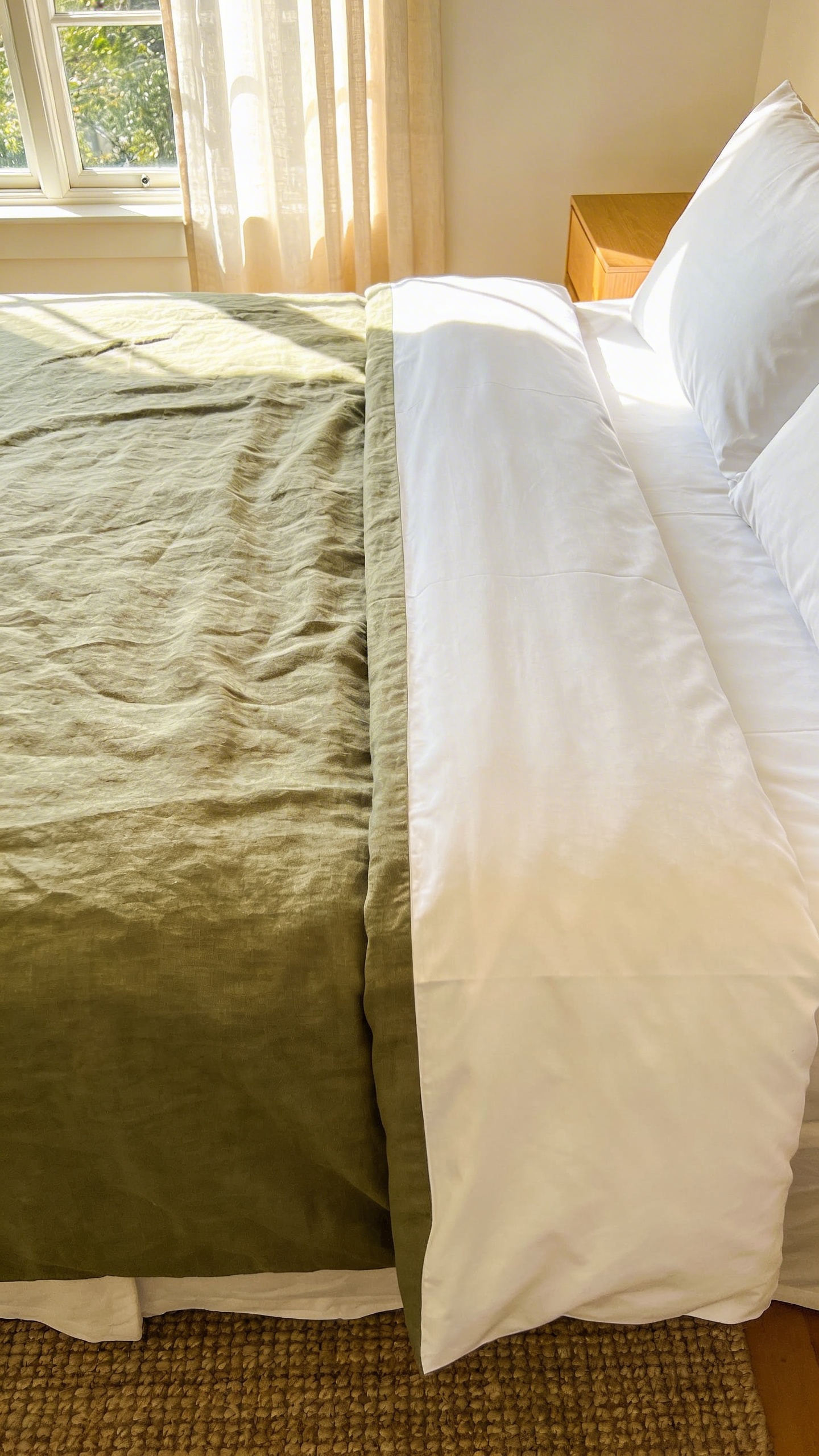 High-quality interior photo of a cozy bedroom featuring the textural contrast between soft rumpled linen and crisp structured percale bedding.