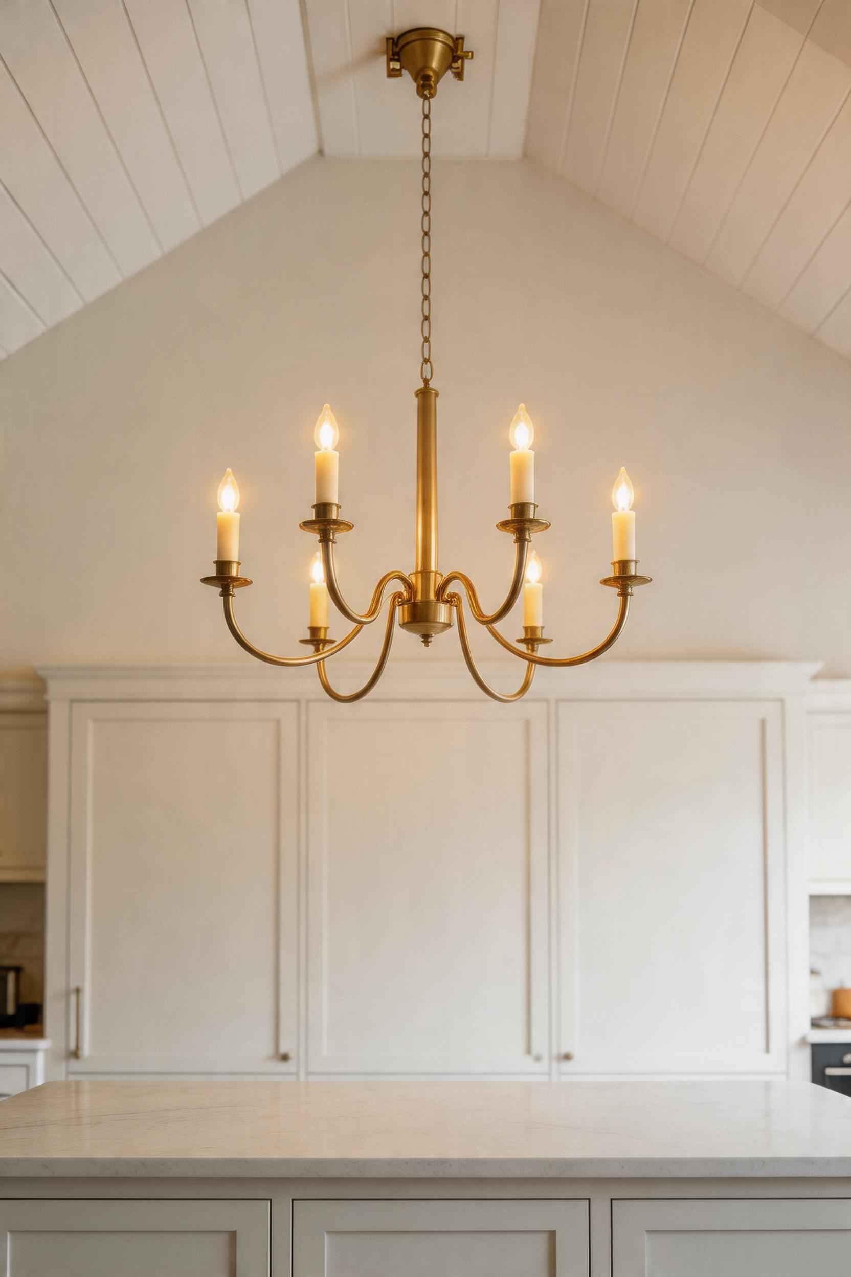 A properly sized and finished statement chandelier creating a focal point over the kitchen island.