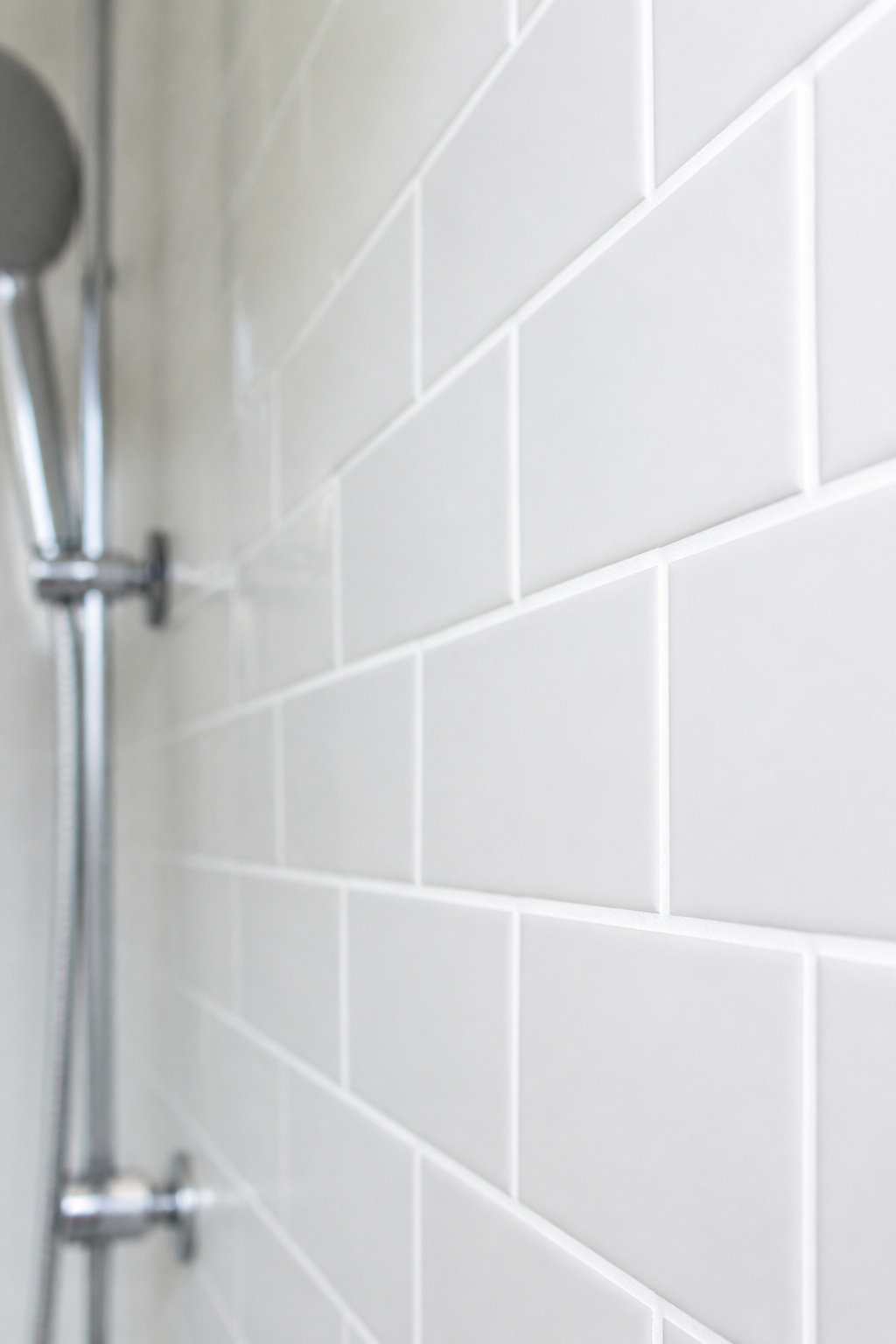 Fresh grout in a slightly darker tone modernizes builder-grade tile without replacing a single piece — the entire budget bathroom remodel impact comes from clean, intentional grout lines.