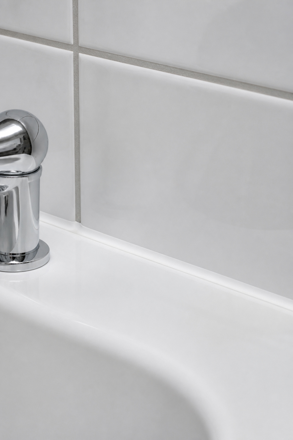 A fresh bead of 100% silicone caulk at the tub-tile joint is the single highest-return hour of labor in a budget bathroom remodel — visible mold at this joint signals active water infiltration that worsens over time.