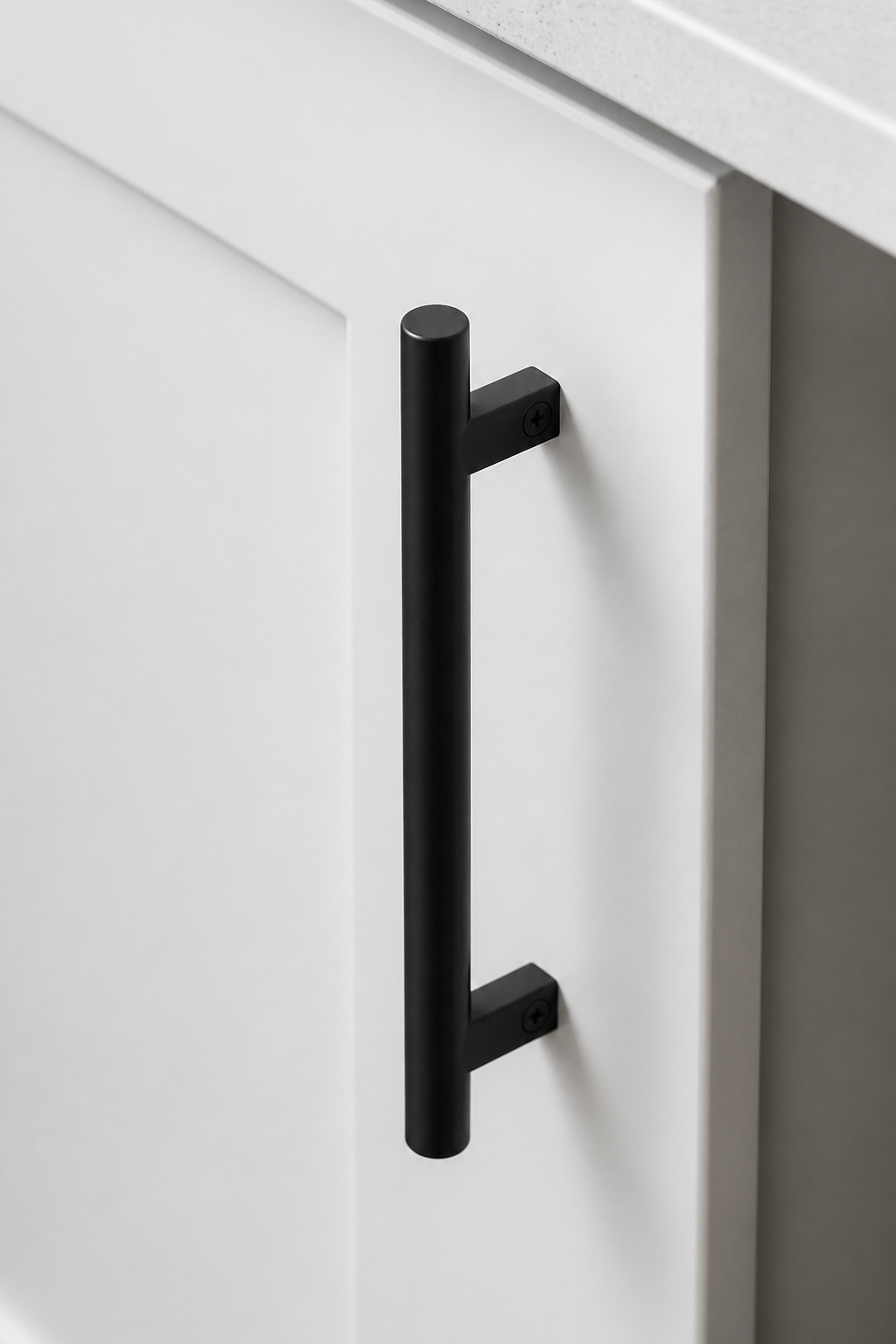 A single matte black bar pull against a freshly painted white shaker door — hardware replacement is the most underrated budget kitchen remodel move for immediate visual impact.