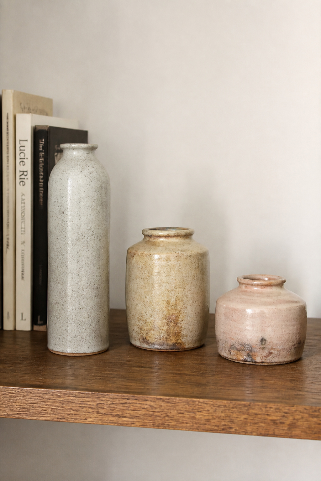 Odd-number triangular grouping at three heights: the composition registers from across the room, and each glaze responds differently to the same light source.