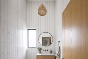 Floor-to-ceiling 4x12 elongated subway tile installed vertically with gray grout creates a strong upward visual movement that makes this small bathroom's 8-foot ceiling feel considerably taller.