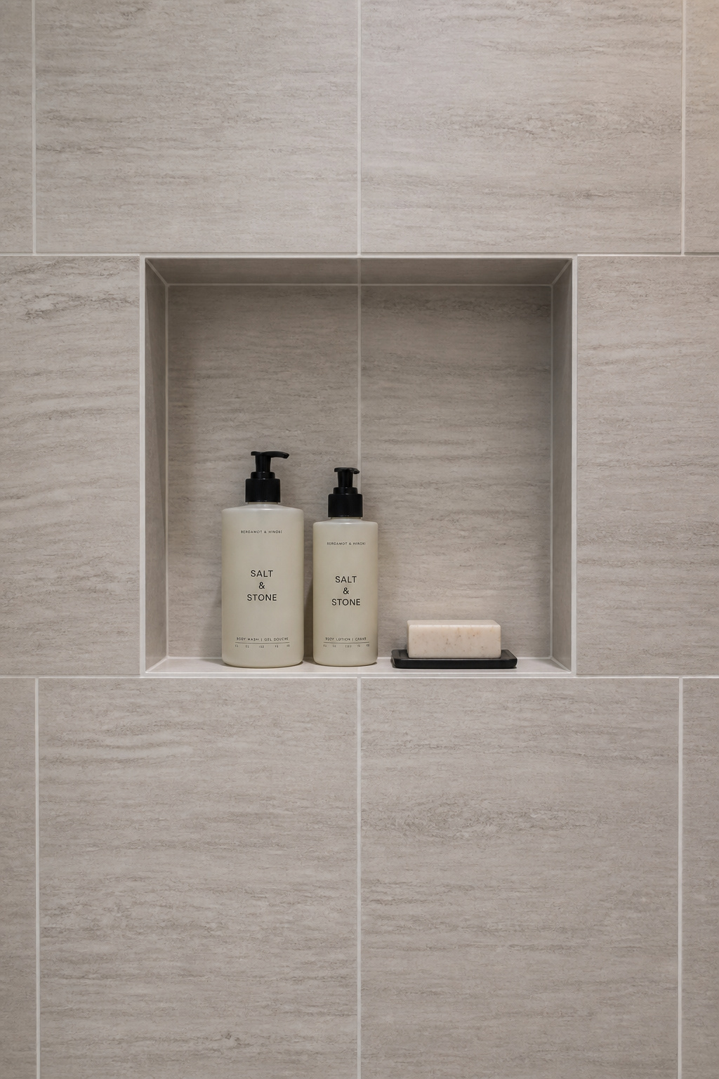 When a niche is tiled to match the surrounding wall and aligned to the grid, it becomes part of the wall itself — storage that disappears when not in use.