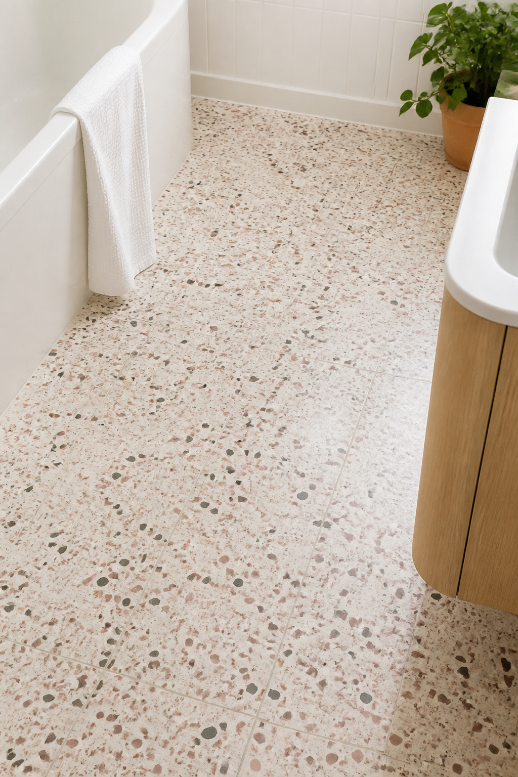 Terrazzo's aggregate pattern reads as fine texture rather than dominant motif — making it one of the most space-friendly patterned floors for compact bathrooms.