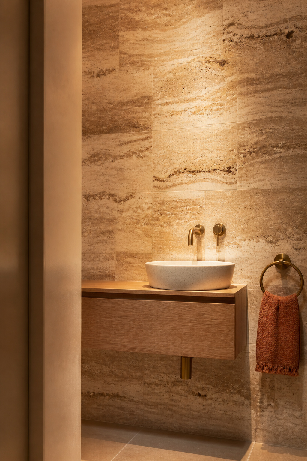 Filled travertine's natural veining transforms a compact bathroom wall into a material statement — each tile different, collectively cohesive.