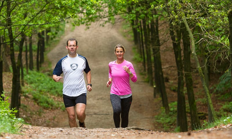 Hardlopende mensen over een bospad