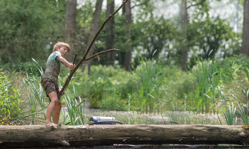 Kinderen spelen met water bij een natuurlijke speelplek van OERRR.