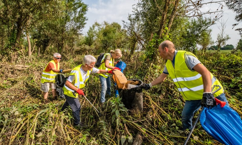 Vrijwilligers doen mee aan een opruimactie Grensmaas