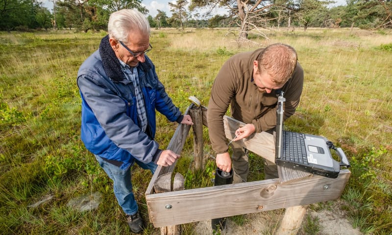 Ward Walraven en Albert Sprengers peilen het water via peilbuis