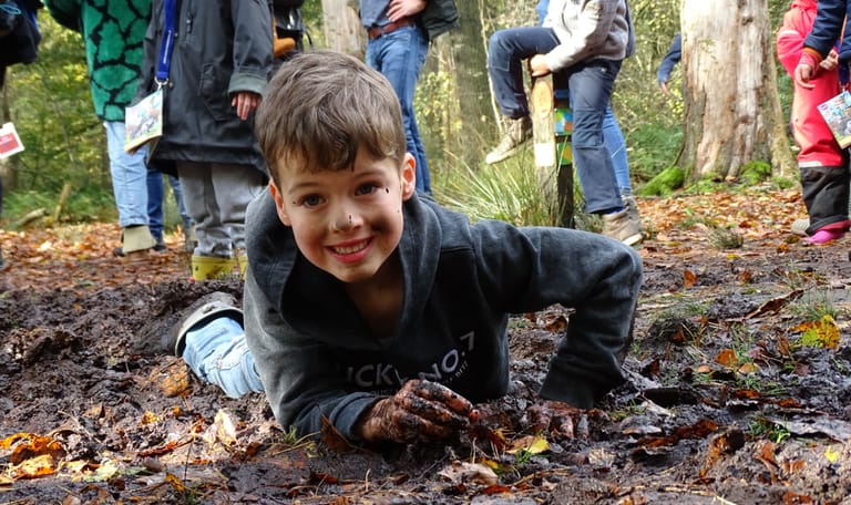 Jongen in modder wilde buitendag