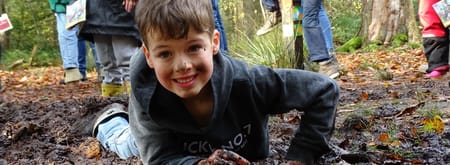 Jongen in modder wilde buitendag