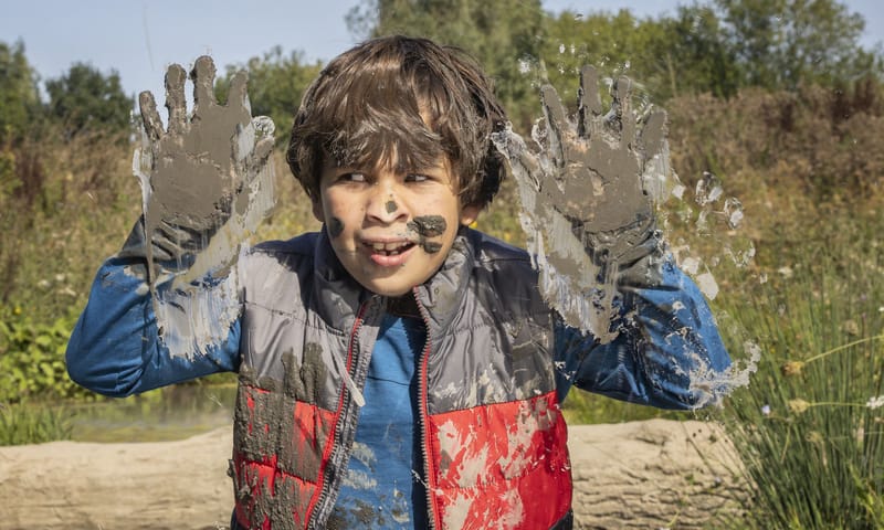 Jongen speelt in de modder