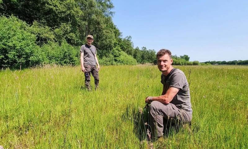 Boswachters Jan en Fred onderzoeken de planten in het gebied