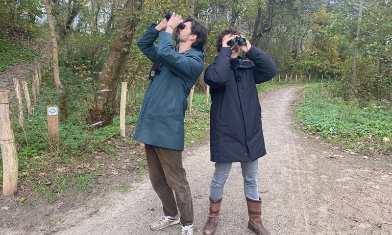 Jesse Klaver en Ruben Hein kijken vogels tijdens podcastwandeling.