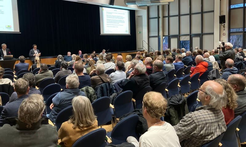 honderden mensen in de zaal bij informatiebijeenkomst Duitse windmolens