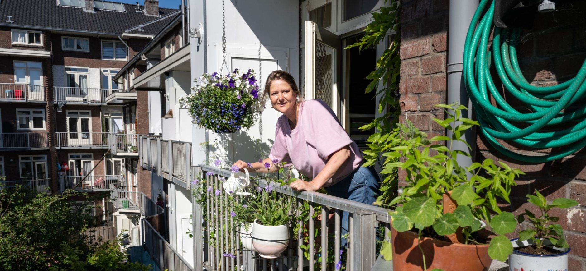 Dame op een plantenrijk balkon