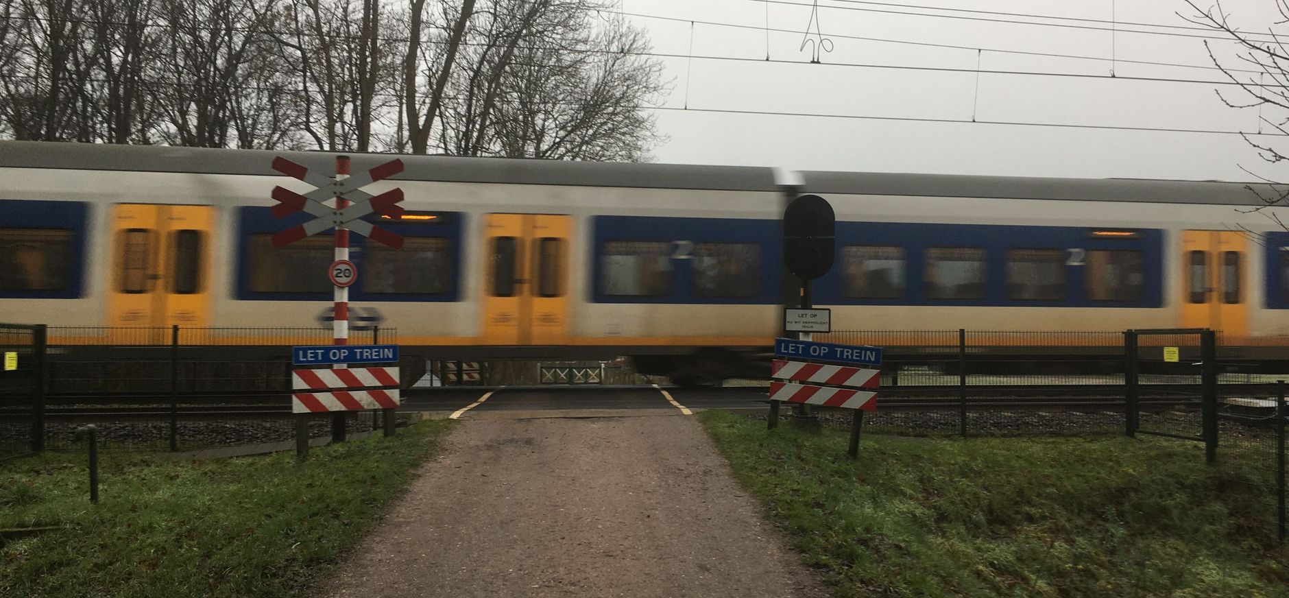 trein raast voorbij bij spoorovergang Kuillaan Nijenburg