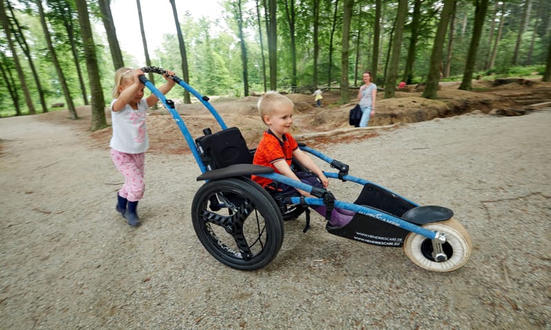 Twee kinderen waarvan eentje in een rolstoel