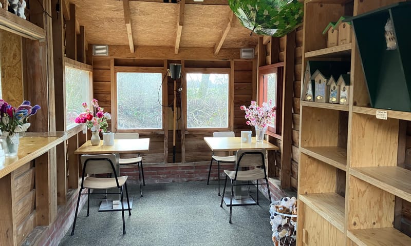 Mini-bezoekerscentrum met tafeltjes en stoelen